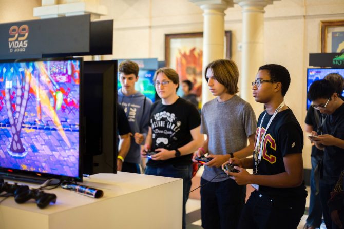 A group of teenage boys playing video games in an independent arcade